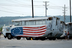 People view a row of idled duck boats in the parking lot of Ride the Ducks Saturday, July 21, 2018 in Branson, Mo. One of the company's duck boats capsized Thursday night resulting in several deaths on Table Rock Lake.