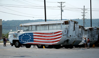 People view a row of idled duck boats in the parking lot of Ride the Ducks Saturday, July 21, 2018 in Branson, Mo. One of the company's duck boats capsized Thursday night resulting in several deaths on Table Rock Lake.