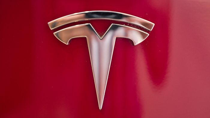 In this Aug. 8, 2018, file photo a Tesla emblem is seen on the back end of a Model S in the Tesla showroom in Santa Monica, Calif.