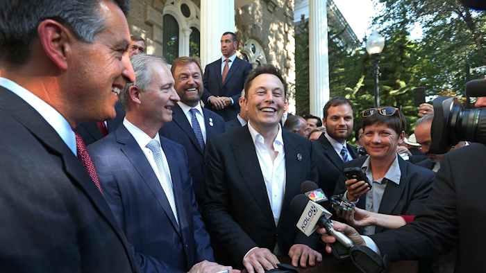 In this Sept. 4, 2014, file photo, Nevada Gov. Brian Sandoval, from left, executive director of the Governor's office of economic development Steve Hill and Tesla Motors CEO Elon Musk answer questions following a news conference at the Capitol in Carson City, Nev.