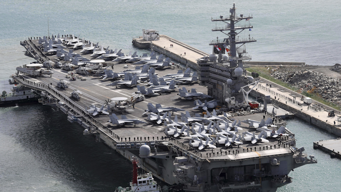 In this Oct. 21, 2017 photo, the aircraft carrier USS Ronald Reagan (CVN 76) is escorted into Busan port, South Korea, after completing a joint drill with the South Korean military.
