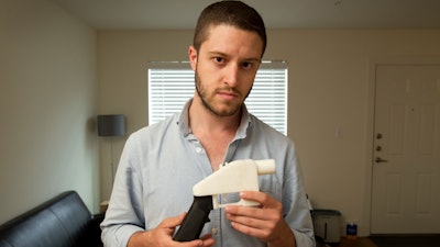 In this May 10, 2013, file photo, Cody Wilson, the founder of Defense Distributed, shows a plastic handgun made on a 3D-printer at his home in Austin, Texas.