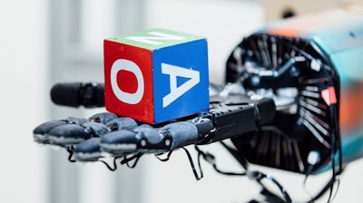 This undated photo provided by OpenAI shows a robotic hand holding a cube at the company's research lab in San Francisco.