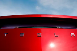 In this April 15, 2018, file photo, the sun shines off the rear deck of a roadster on a Tesla dealer's lot in the south Denver suburb of Littleton, Colo.