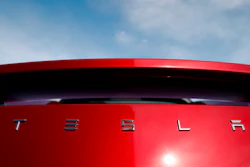 In this April 15, 2018, file photo, the sun shines off the rear deck of a roadster on a Tesla dealer's lot in the south Denver suburb of Littleton, Colo.