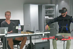 Robotics expert on the Ecole Polytechnique Federal de Lausanne, EPFL team, Matteo Macchini, right, displays the fly controls in a virtual reality scenario as he controls the flight of a drone.