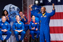 Astronaut Victor Glover raises his arms after being introduced during a NASA event to announce the astronauts assigned to crew the first flight tests and missions of the Boeing CST-100 Starliner and SpaceX Crew Dragon.