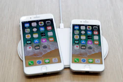 In this Sept. 12, 2017, file photo the new AirPower wireless charger and iPhones are displayed in the showroom after the new product announcement at the Steve Jobs Theater on the new Apple campus in Cupertino, Calif.