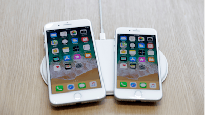 In this Sept. 12, 2017, file photo the new AirPower wireless charger and iPhones are displayed in the showroom after the new product announcement at the Steve Jobs Theater on the new Apple campus in Cupertino, Calif.