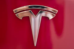 In this Aug. 8, 2018, file photo a Tesla emblem is seen on the back end of a Model S in the Tesla showroom in Santa Monica, Calif.