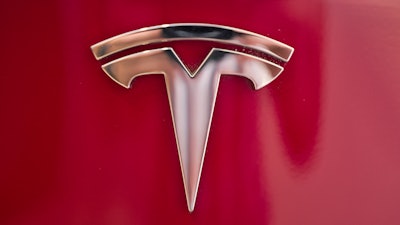 In this Aug. 8, 2018, file photo a Tesla emblem is seen on the back end of a Model S in the Tesla showroom in Santa Monica, Calif.