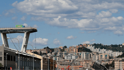 A truck perches on the edge of the Morandi highway bridge that collapsed in Genoa, northern Italy, Wednesday, Aug. 15, 2018.