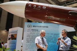 In this Aug. 13, 2015, file photo, two men speak under the Taiwan-made 'Tien-Kung III' surface to air missile during the 2015 Taipei Aerospace and Defense Technology Exhibition in Taipei, Taiwan.
