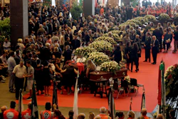 People gather for a funeral service for some of the victims of a collapsed highway bridge, in Genoa's exhibition center Fiera di Genova, Italy, Saturday, Aug. 18, 2018.