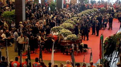 People gather for a funeral service for some of the victims of a collapsed highway bridge, in Genoa's exhibition center Fiera di Genova, Italy, Saturday, Aug. 18, 2018.