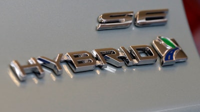 This Feb. 14, 2013, file photo shows a hybrid logo on the back of a Ford Fusion hybrid automobile at the 2013 Pittsburgh Auto Show in Pittsburgh.