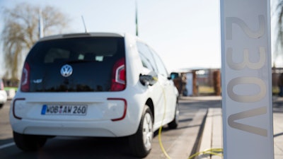 In this March 8, 2014 photo a Volkswagen e-up electric car is recharged on a recharging station in front of a building of the Volkswagen AG in Wolfsburg, Germany.