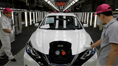 Chinese workers inspect a Nissan Sylphy Zero Emission, Nissan's first all-electric vehicle built in China, at a production line in Guangzhou, Guangdong province, China, Monday, Aug. 27, 2018.