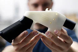 In this Aug. 1, 2018, file photo, Cody Wilson, with Defense Distributed, holds a 3D-printed gun called the Liberator at his shop in Austin, Texas.
