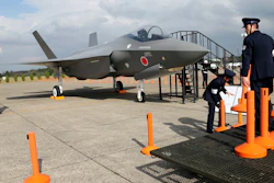 In this Oct. 26, 2014, file photo, Japan Air Self-Defense Force crew members set up cordons to protect a mockup of the F-35 fighter jet during the annual Self-Defense Forces Commencement of Air Review at Hyakuri Air Base, north of Tokyo.
