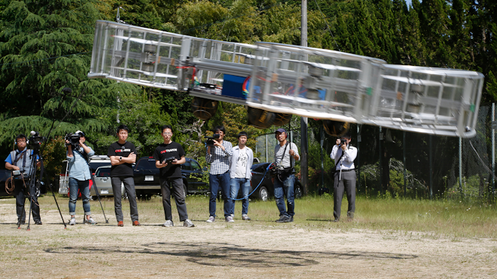 In this Saturday, June 3, 2017, file photo, Tsubasa Nakamura, project leader of Cartivator, third from left, watches the flight of the test model of the flying car on a former school ground in Toyota, central Japan.