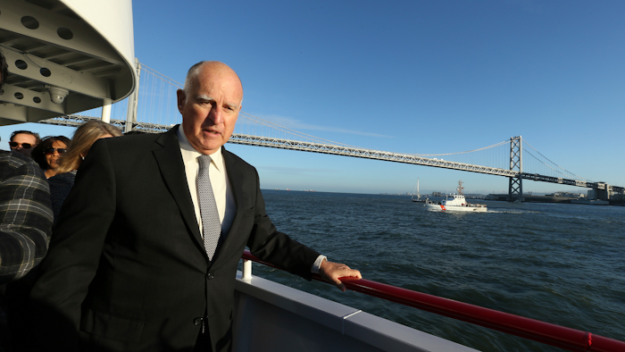 California Gov. Jerry Brown walks to the bow of the high-tech battery-operated San Francisco Bay sightseeing boat, Enhydra, for a cruise of San Francisco Bay, where he signed 16 new laws aimed at easing global warming.