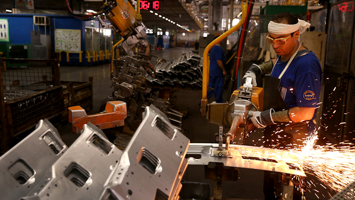 In this Sunday, Sept. 9, 2018 photo, a worker welds parts of a car body at the Iran Khodro automobile manufacturing plant, just outside Tehran.