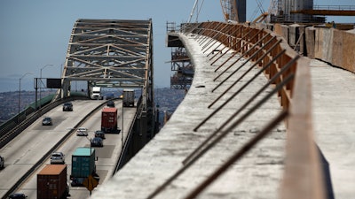 In this July 2, 2018, photo, traffic moves on the old Gerald Desmond Bridge next to its replacement bridge under construction in Long Beach, Calif.