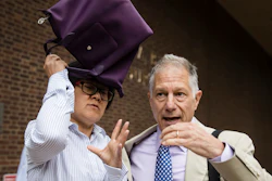 Yu Xue, left, accompanied by her attorney Peter Zeidenberg attempts to block her face with her bag as they exit the federal courthouse in Philadelphia, Friday, Aug. 31, 2018.