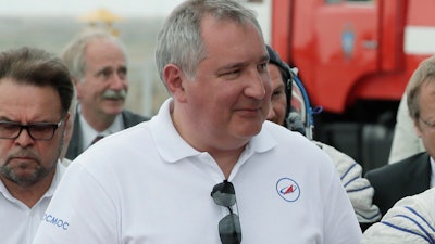In this file photo dated Wednesday, June 6, 2018, Roscosmos state space corporation head Dmitry Rogozin, accompanies new International Space Station crew members, to the rocket prior the launch at the Russian leased Baikonur cosmodrome, Kazakhstan.