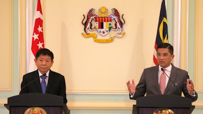 Malaysia's Minister of Economic Affair Mohamed Azmin Ali, right, and Minister for Infrastructure and Minister for Transport of Singapore Khaw Boon Wan, left, speak during a press conference at Prime Minister Office in Putrajaya, Malaysia, Wednesday, Sept. 5, 2018.