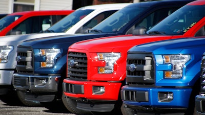 In this Nov. 19, 2015, file photo a row of 2015 Ford F-150 pickup trucks are parked on the sales lot at Butler County Ford in Butler, Pa.