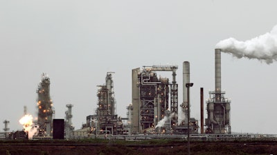 This April 2, 2010 file photo shows a Tesoro Corp. refinery, including a gas flare flame that is part of normal plant operations, in Anacortes, Wash.