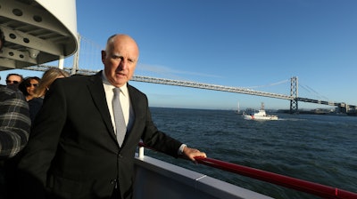 California Gov. Jerry Brown walks to the bow of the high-tech battery-operated San Francisco Bay sightseeing boat, Enhydra, for a cruise of San Francisco Bay, where he signed 16 new laws aimed at easing global warming.