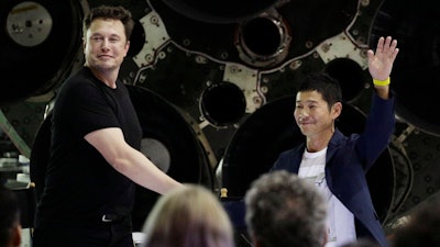 SpaceX founder and chief executive Elon Musk, left, shakes hands with Japanese billionaire Yusaku Maezawa, right, after announcing him as the first private passenger on a trip around the moon, Monday, Sept. 17, 2018, in Hawthorne, Calif.