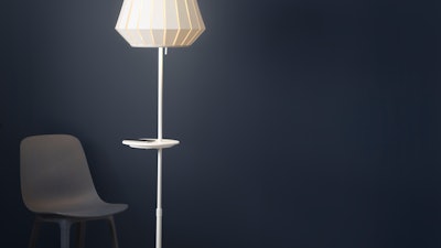 This undated photo provided by Inter IKEA Systems B.V. 2018 shows the VARV floor lamp, which allows you to charge 2 devices at once with a USB port built into the lamp, and a built in charger on the table for wireless charging.