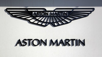 In this file photo dated Wednesday, Feb. 24, 2016, an Aston Martin sign is seen outside a dealership on Park Lane in London.