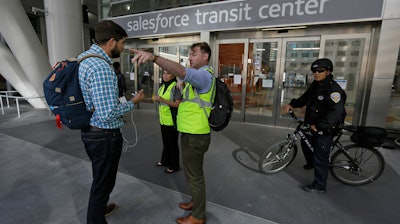 Mike Eshleman, with AC Transit, directs people away from the Salesforce Transit Center following its closure, Tuesday, Sept. 25, 2018, in San Francisco.