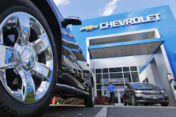 This Wednesday, April 26, 2017, photo shows the logo on the wheel of an SUV in front of a Chevrolet dealership in Richmond, Va.
