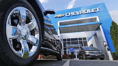 This Wednesday, April 26, 2017, photo shows the logo on the wheel of an SUV in front of a Chevrolet dealership in Richmond, Va.