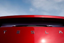 In this April 15, 2018, file photo, the sun shines off the rear deck of a roadster on a Tesla dealer's lot in the south Denver suburb of Littleton, Colo.