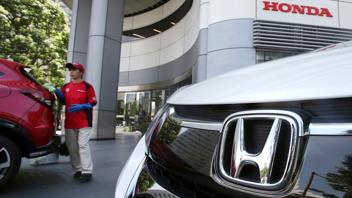 In this July 31, 2018, file photo, an employee of Honda Motor Co. cleans a Honda car displayed at its headquarters in Tokyo.