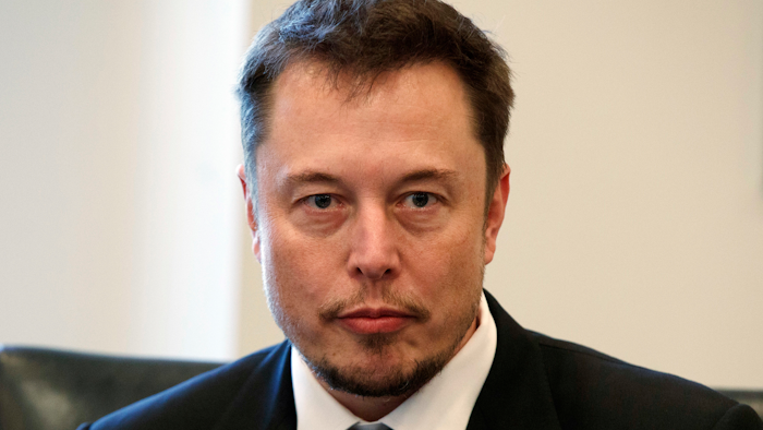 In this Dec. 14, 2016, file photo, Tesla CEO Elon Musk listens as President-elect Donald Trump speaks during a meeting with technology industry leaders at Trump Tower in New York.