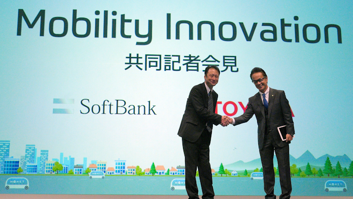 Representative Director and CTO of SoftBank Corp. Junichi Miyakawa, left and Executive Vice President of Toyota Motor Corporation Shigeki Tomoyama, right, shake hands during a press conference in Tokyo Thursday, Oct. 4, 2018.