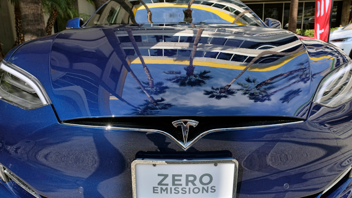 In this Oct. 24, 2016, file photo, palm trees are reflected on the hood of a Tesla Model S on display in downtown Los Angeles.