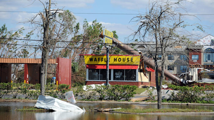 In this Sunday, Oct. 14, 2018, photo, a billboard lies atop a Waffle House restaurant after being knocked down by Hurricane Michael, in Panama City, Fla.