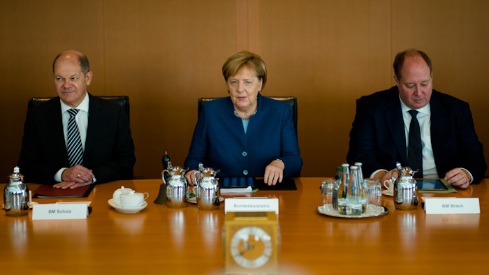 German Chancellor Angela Merkel sits between Vice-chancellor and Finance Minister Olaf Scholz, left, Head of Chancellery and Minister for Special Tasks Helge Braun, right, as she leads the weekly cabinet meeting of the German government at the chancellery in Berlin, Wednesday, Oct. 24, 2018.