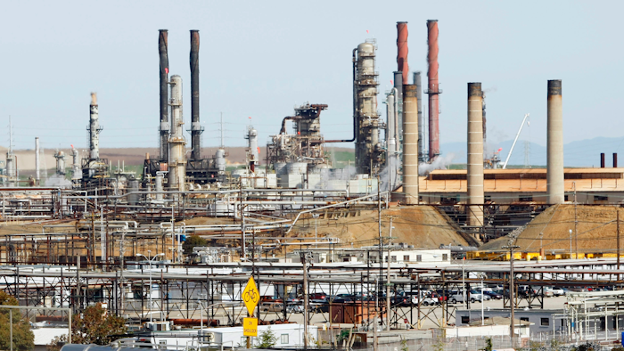 This March 9, 2010, file photo shows a tanker truck passing the Chevron oil refinery in Richmond, Calif.