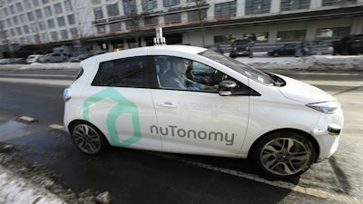 In this Tuesday, Jan. 10, 2017, photo, an autonomous vehicle is driven by an engineer on a street through an industrial park, in Boston.