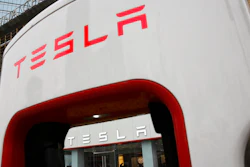 In this April 5, 2018, file photo, a sales person stands inside a Tesla electric vehicle showroom in Beijing.